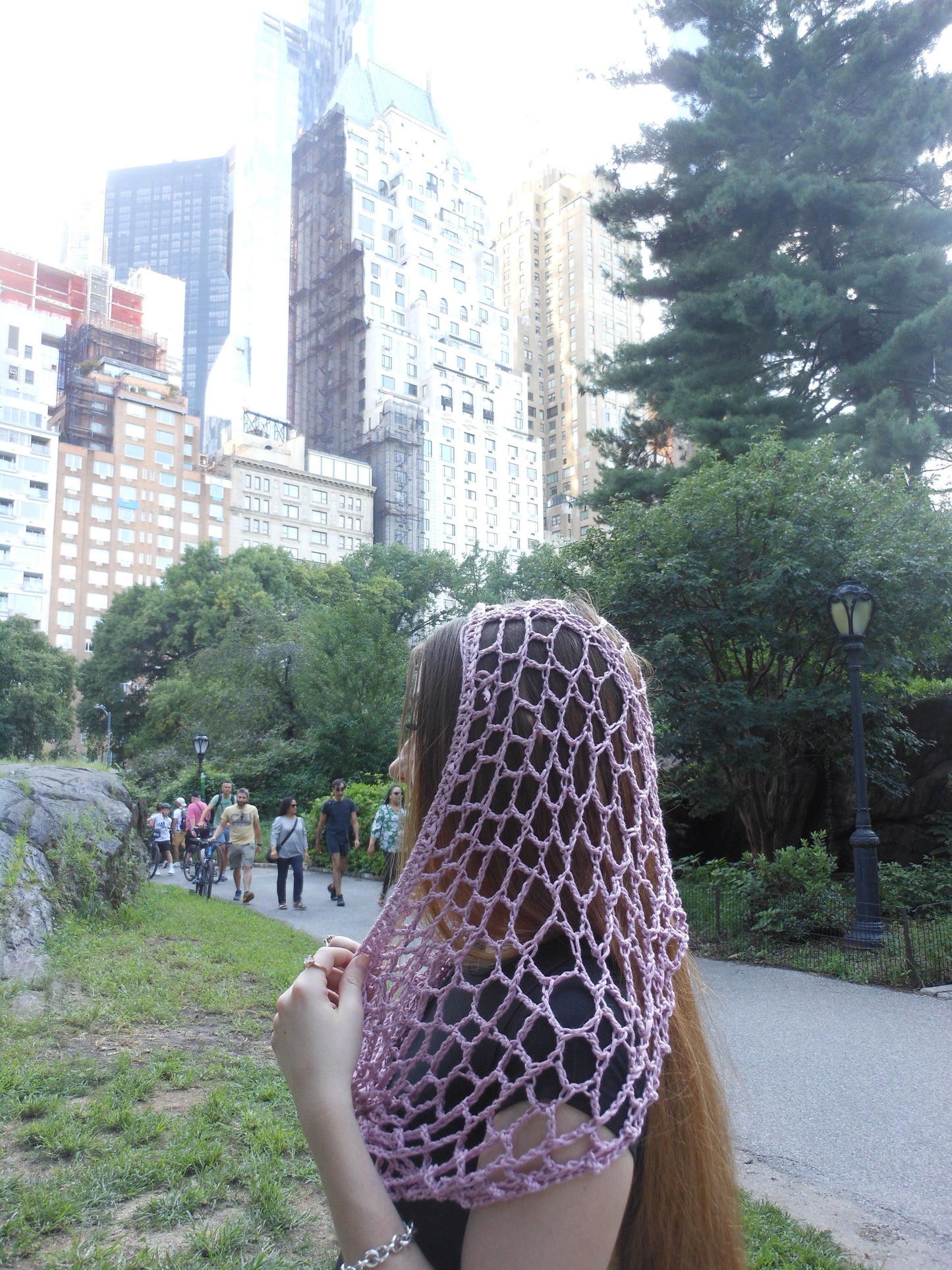 Pink spiderweb crochet hood with hood crochet design, worn as a hood for festival, rave, or concert fashion.