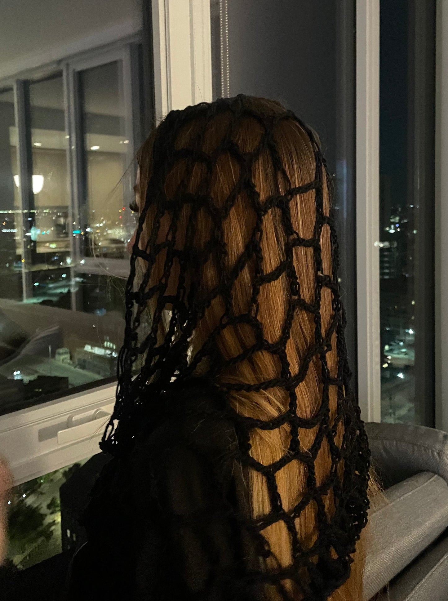 Black spiderweb crochet hood with hood crochet design, worn as a hood for festival, rave, or concert fashion.