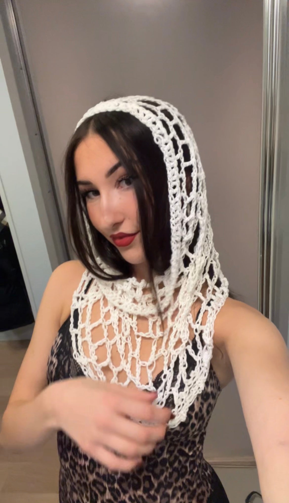 White spiderweb crochet hood with hood crochet design, worn as a hood for festival, rave, or concert fashion.
